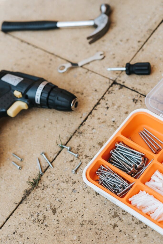 repair-tools-in-container-with-hammer-and-screwdriver-4792478 From above of assorted carpentry tools in plastic case placed with metal hammer and screwdriver